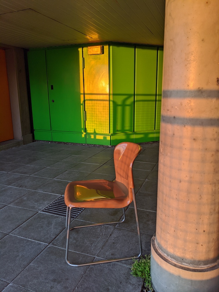 Photograph looking back onto the hospital balcony showing an empty plastic chair.