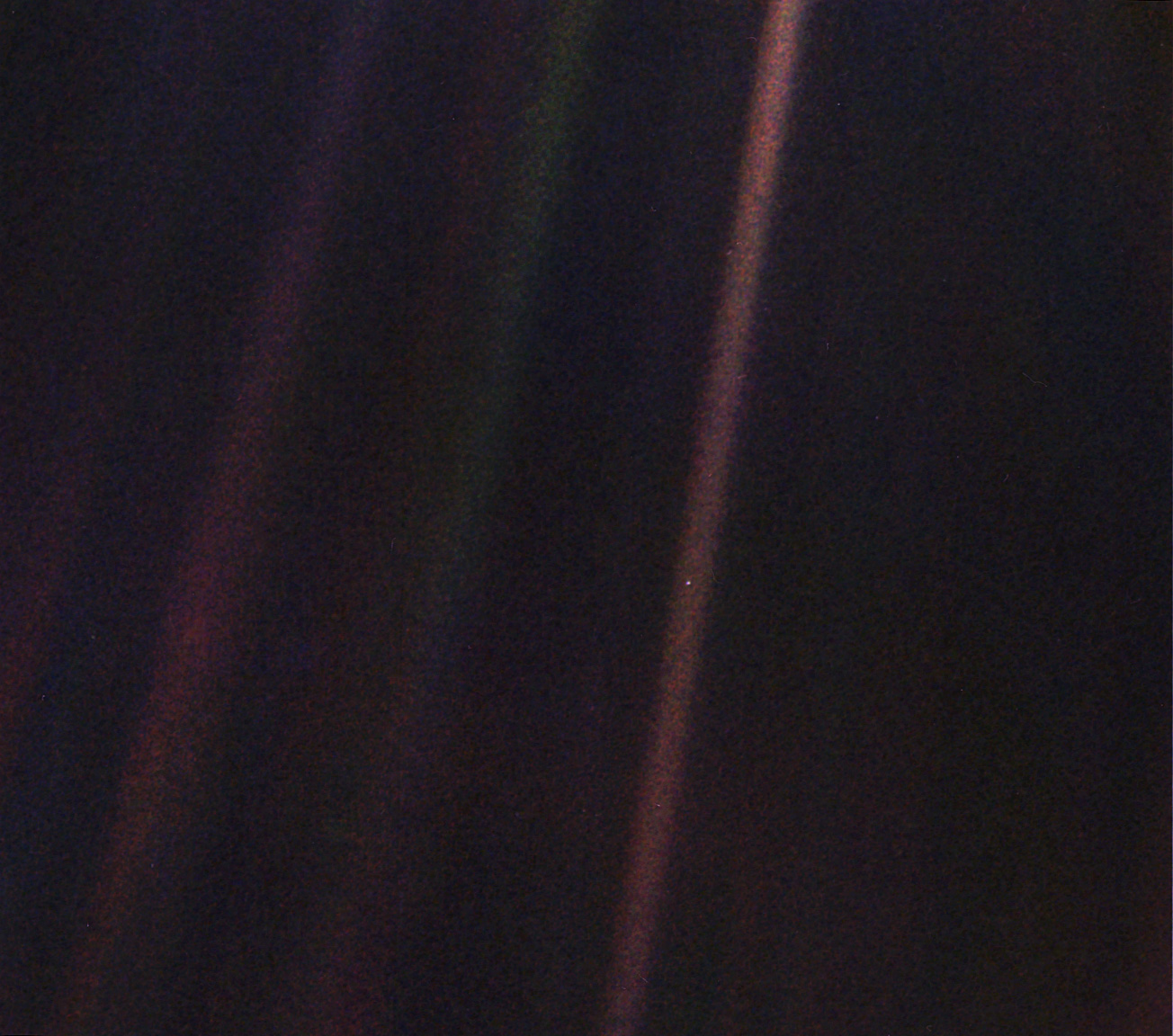 A photograph taken from the spacecraft Voyager as it turns to face Earth one final time. In this photo, Earth is a tiny speck of light, hanging in the void.